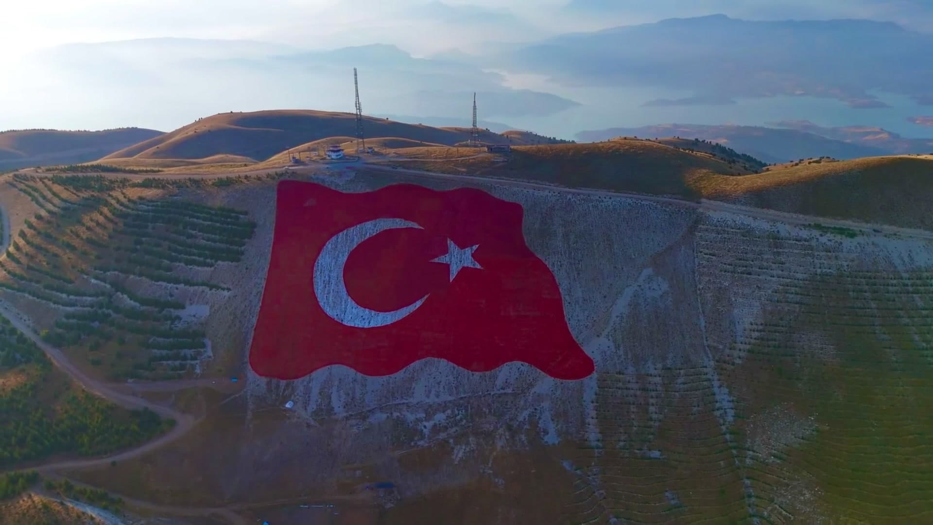 Kahramanmaraş dağlarında Türk bayrağının yer aldığı gün batımı manzarası